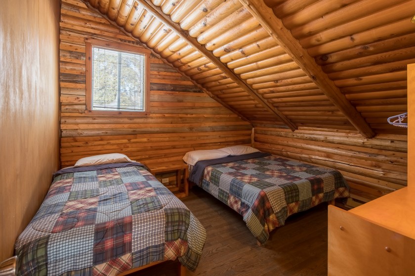 Chalet #6 at Pourvoirie Mekoos. Upstairs bedroom with 1 single and 1 double bed